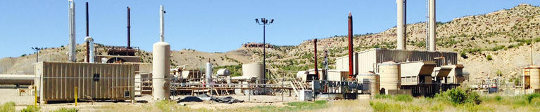 Area gas well in a field with rolling hills in the background